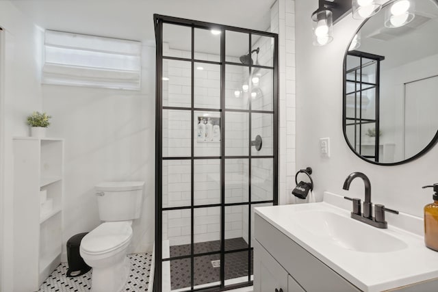 bathroom with vanity, a shower with door, tile patterned floors, and toilet