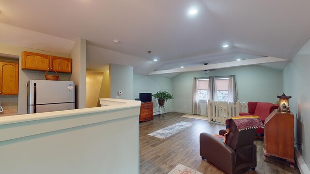 kitchen with hardwood / wood-style flooring, lofted ceiling, a baseboard radiator, and white fridge