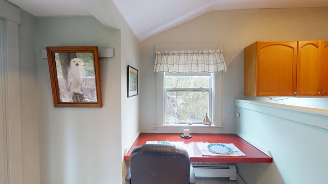 office space with lofted ceiling and a baseboard heating unit