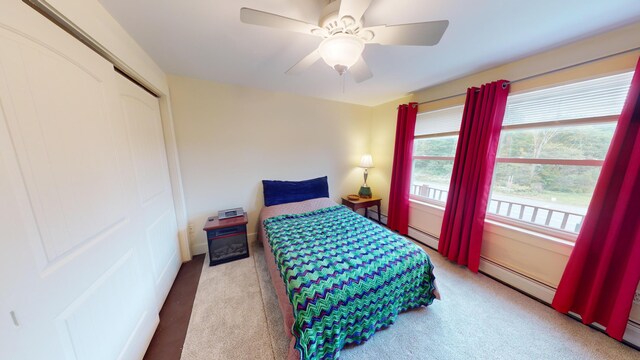 bedroom featuring a closet, ceiling fan, baseboard heating, and carpet floors