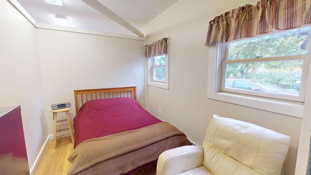 bedroom with wood-type flooring and vaulted ceiling