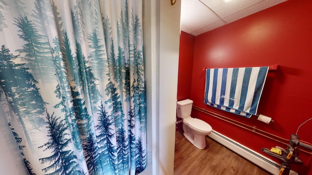 bathroom with a shower with curtain, hardwood / wood-style floors, toilet, and a baseboard radiator