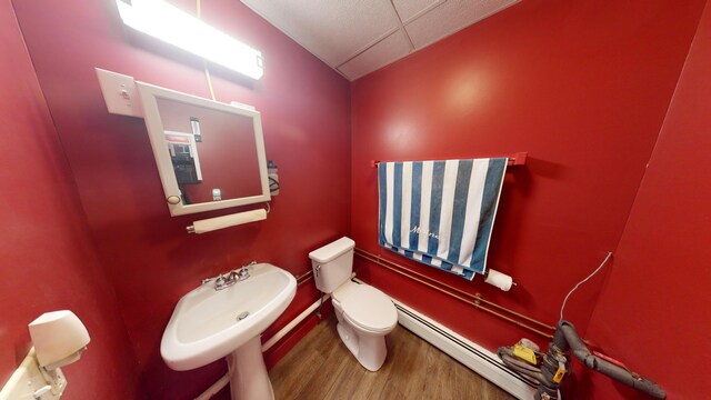 bathroom with hardwood / wood-style flooring, toilet, and a baseboard radiator