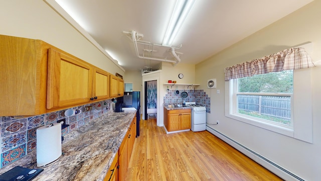 kitchen featuring white range, light hardwood / wood-style floors, sink, a baseboard radiator, and decorative backsplash