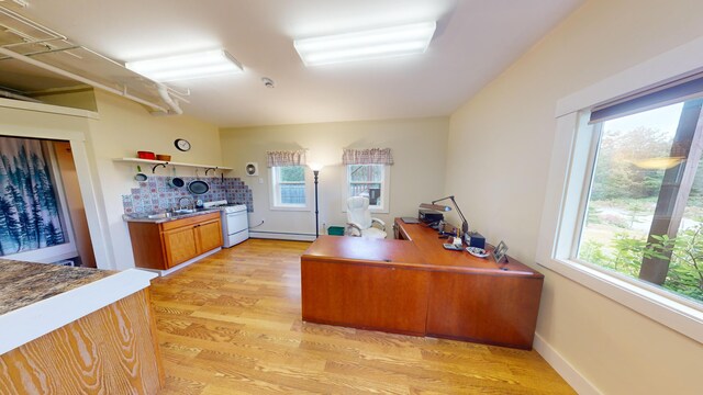 office area with light wood-type flooring and baseboard heating