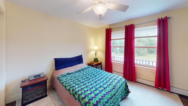 bedroom with baseboard heating, ceiling fan, and light colored carpet