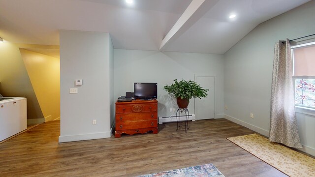 living area with a baseboard radiator, light wood-type flooring, and lofted ceiling