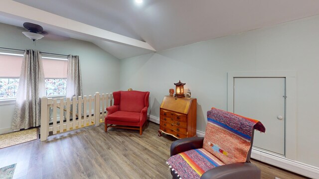 living area featuring wood-type flooring, vaulted ceiling, and a baseboard heating unit