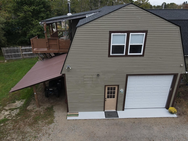 rear view of house with a deck and a garage