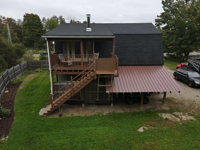 back of house featuring a lawn and a deck