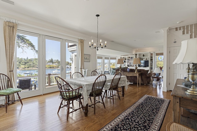 12 Steamboat Wharf Ln, Harpswell, ME 04079 - dining space with an inviting chandelier, a water view, french doors, and wood finished floors