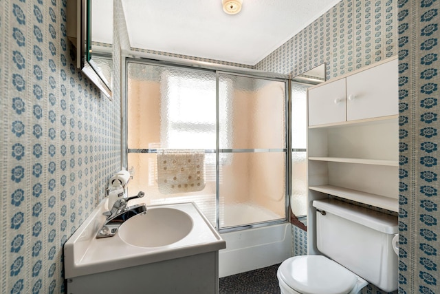 bathroom featuring wallpapered walls, shower / bath combination with glass door, toilet, and vanity