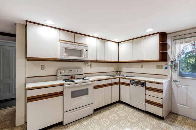 kitchen with light countertops, white appliances, recessed lighting, white cabinetry, and a sink