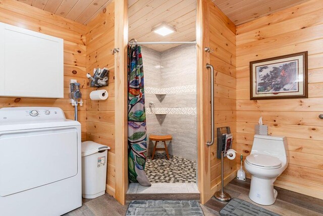 clothes washing area with wooden ceiling, wood walls, hardwood / wood-style floors, and washer / dryer