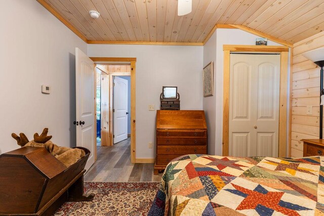 bedroom featuring wooden ceiling, lofted ceiling, dark wood-type flooring, and a closet