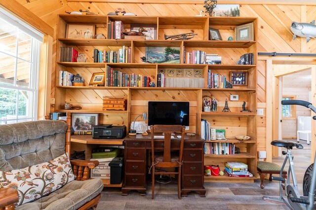 office with wood-type flooring and wood walls