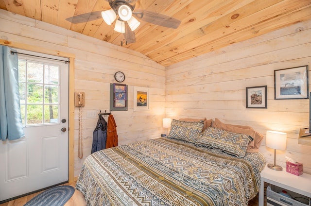 bedroom with lofted ceiling, ceiling fan, wood walls, and wooden ceiling