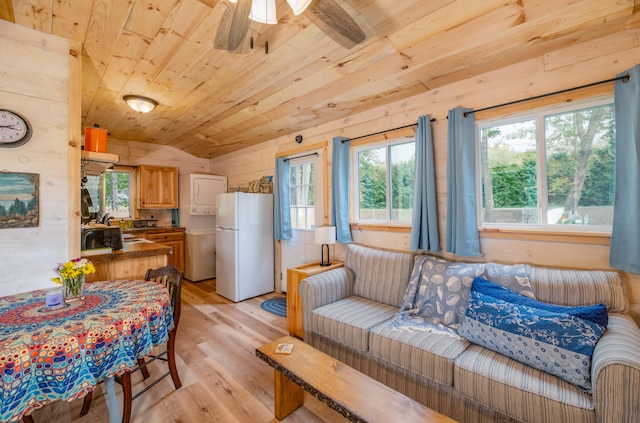 living room featuring wood ceiling, vaulted ceiling, light wood-type flooring, ceiling fan, and wooden walls