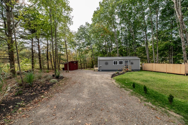 view of front of home with a storage unit and a front lawn