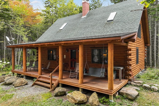 rear view of property featuring a wooden deck