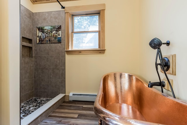 bathroom with hardwood / wood-style flooring, baseboard heating, and tiled shower