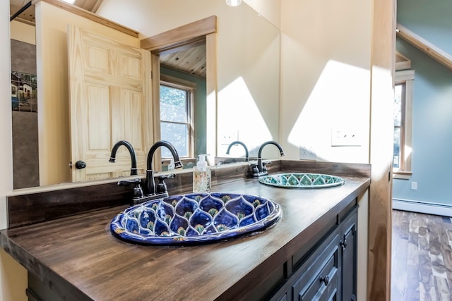 bathroom with a baseboard radiator, wood-type flooring, and vanity