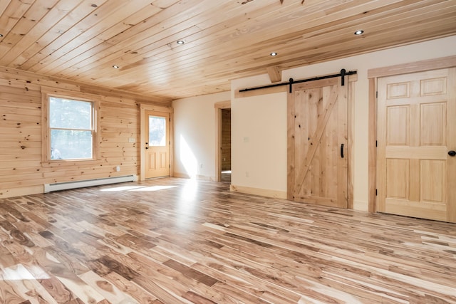 spare room with wood walls, light hardwood / wood-style flooring, wooden ceiling, a baseboard radiator, and a barn door