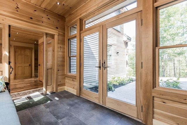 doorway with wood ceiling and wood walls