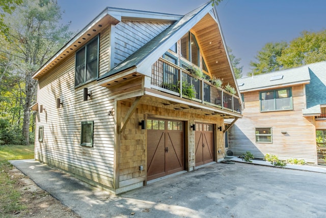 view of front of property featuring a balcony and a garage