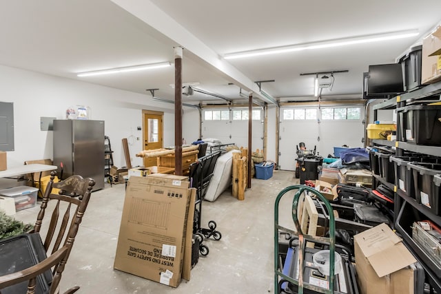 garage with stainless steel refrigerator, electric panel, and a garage door opener