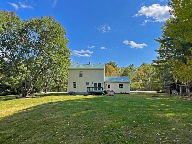 back of house with a deck and a lawn