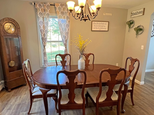 dining space featuring an inviting chandelier and hardwood / wood-style flooring