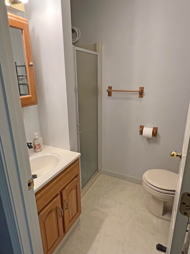 bathroom with a shower with door, vanity, and toilet