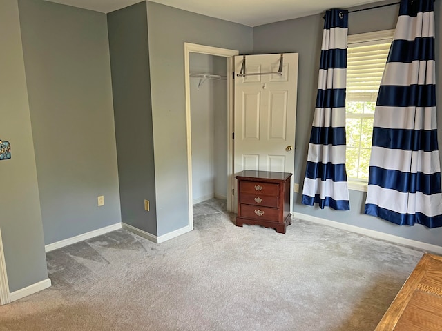 unfurnished bedroom with a closet and light colored carpet