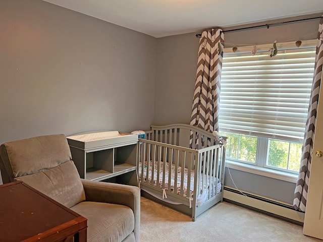 bedroom with light colored carpet, baseboard heating, and a nursery area