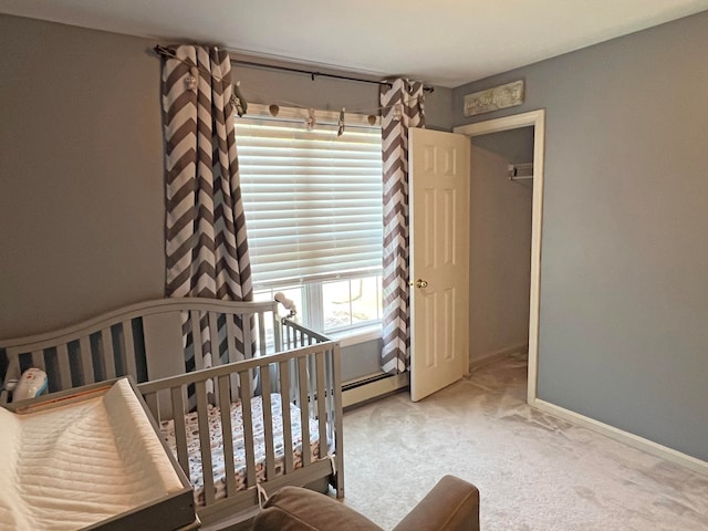 bedroom featuring a crib, baseboard heating, and light carpet