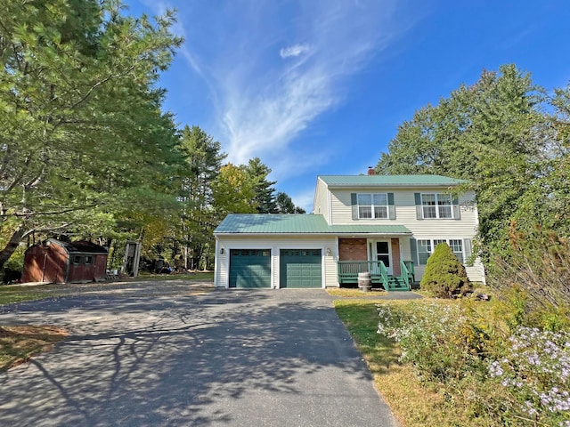 view of front facade featuring a shed, a garage, and covered porch