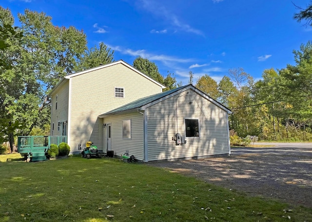 rear view of property with a deck and a lawn