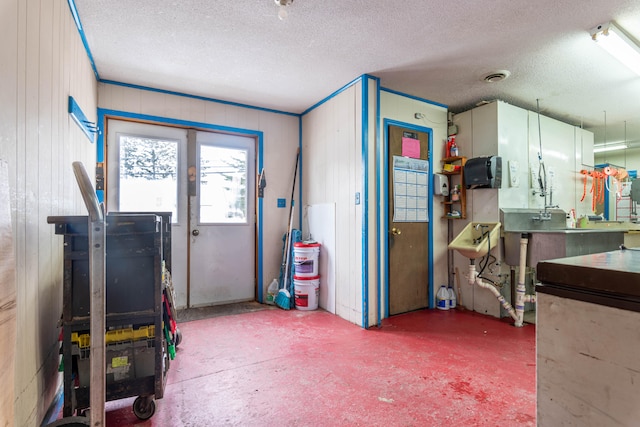 misc room with a textured ceiling, a workshop area, and concrete floors