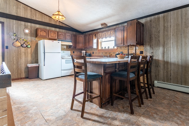 kitchen featuring pendant lighting, white appliances, a textured ceiling, wooden walls, and a breakfast bar area