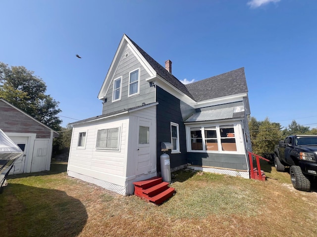 rear view of house featuring a lawn