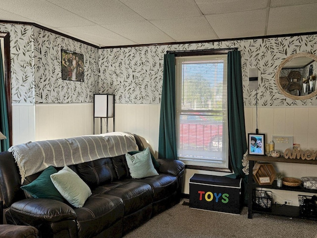 living room with a drop ceiling, plenty of natural light, and carpet flooring