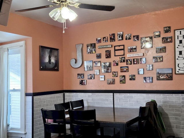 dining area with tile walls and ceiling fan