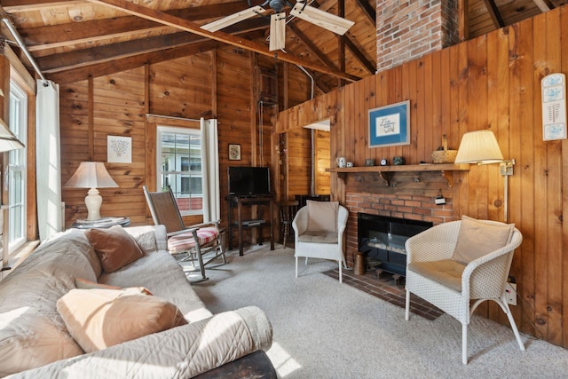 carpeted living room featuring high vaulted ceiling, a brick fireplace, ceiling fan, and beamed ceiling