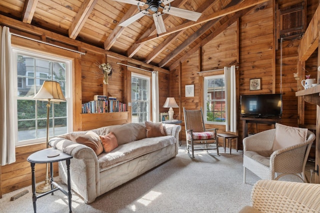 carpeted living room featuring wood ceiling, wooden walls, ceiling fan, and a wealth of natural light