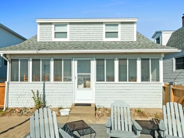 rear view of property featuring a sunroom