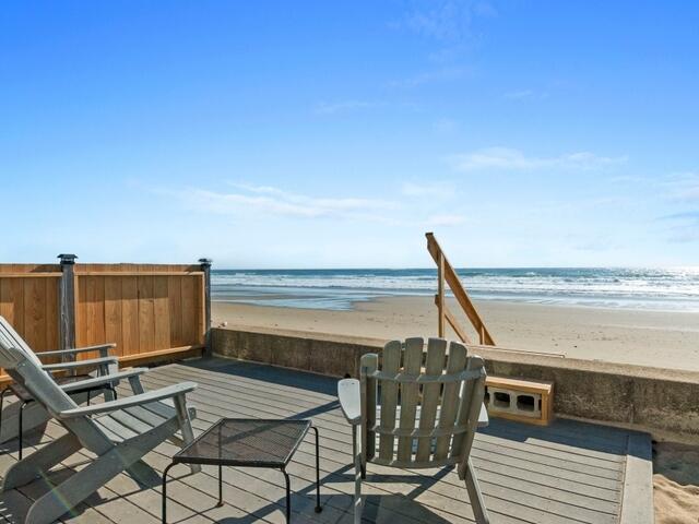 wooden terrace featuring a view of the beach and a water view