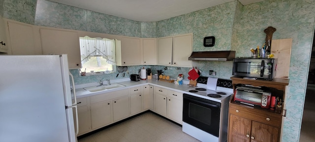 kitchen featuring white appliances, range hood, white cabinets, and sink