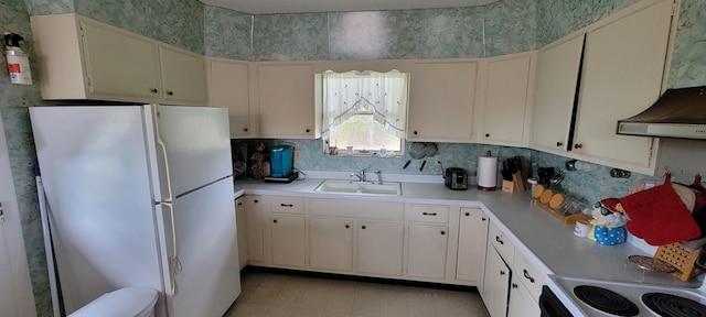 kitchen with white fridge, ventilation hood, sink, and white cabinets