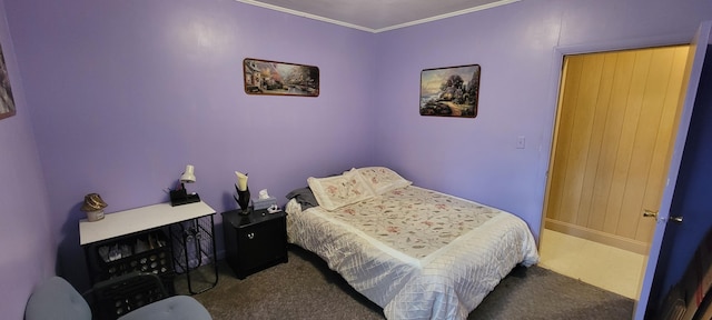 bedroom with ornamental molding and dark colored carpet